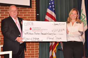 GPCA President Manuel Snipes, presents a check to Emily Kallos at the GPCA Winter Conference, representing a decade of fundraising for the Leukemia & Lymphoma Society.