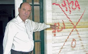 Martin points to a water line on a home, illustrating the devastation Hurricane Katrina caused.Photo: Courtesy of Joe Martin