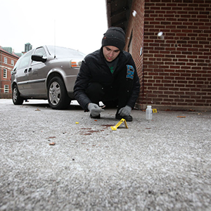 Student investigates the ground at a test crime scene in the snow. Photo: Tom Campbell