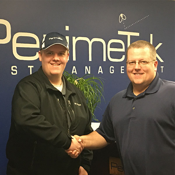 Andrew Sanefski, president of Perimetek Pest Management (right) congratulates Griffin Hunt on his new position. PHOTO: PERIMETEK PEST MANAGEMENT