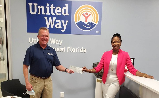 McCall Service CFO David Cooksey presents the donation to Alecia Givens, development manager of United Way of Northeast Florida. IMAGE: KEITH DAVIDSON/MCCALL SERVICE