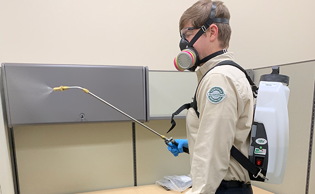 Versacor Total Quality Manager Ryan Gates performs the disinfection service at an office account. PHOTO: VERSACOR ENTERPRISES