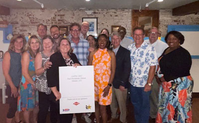 Newly installed AAPSE President Faye Golden, in orange dress, is surrounded by past presidents at the event's closing dinner reception. IMAGE: AAPSE