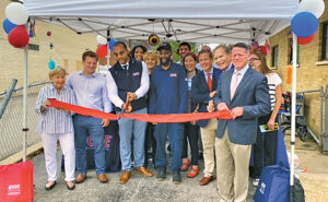 Wesley Price, the Beverly branch’s manager, wields the ribbon-cutting scissors. Cheering him on are, from left, Judy and grandson Bobby Dold; Price; Shalonda Cannon, Rose Care Center manager; Lisa McNamara, Rose sales professional; Earl Jones, Rose service professional; Dan Yunez, Rose controller; Janelle “Bug Girl” Iaccino, Rose marketing director; Bob Jr. and Bob Sr.; Curtis Rand, Rose VP of operations; and Allison Beach, Rose technical specialist. (PHOTO: ROSE PEST SOLUTIONS)
