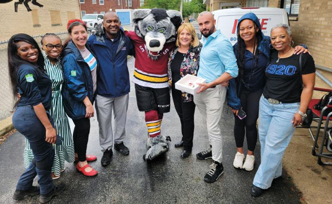 Skates the Gray Wolf is the Chicago Wolves Hockey Team mascot and a big fan of Rose Pest Solutions. Celebrating the open house with him are, from left, Quiana Maxwell, Rose service professional; Kendra Cox, Rose office support; Janelle “Bug Girl” Iaccino, Rose marketing director; Darren Crawford, Rose sales professional; Skates; Rose sales professionals Lisa McNamara and Andrew La Luz; and marketing coordinator Ravin McMorris with her mom, Robin McMorris. (PHOTO: ROSE PEST SOLUTIONS)