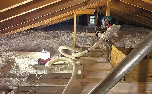 A Whitmore Pest & Wildlife Control restoration technician replaces the old attic insulation that was removed with new, more energy-efficient insulation. (PHOTO: WHITMORE PEST & WILDLIFE CONTROL)