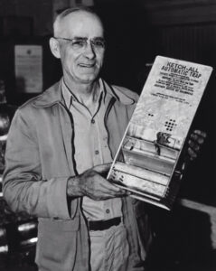 A.E. Kness, as he was known in newspaper articles of the time, shows off an early model of the Ketch-All Automatic Trap. PHOTO: KNESS PEST DEFENSE
