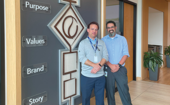 Christopher Gigley, left, and Marshall Gaster stand in the new Syngenta Crop Protection headquarters lobby, next to a structure that highlights the company’s mission. (Photo: PMP Staff)