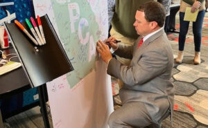 To celebrate the anniversary, Corteva provided a banner of honor for all to sign. Georgia Department of Agriculture Commission, Tyler Harper spoke and signed the banner. PHOTO COURTESY OF GPCA