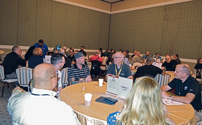 Groups of attendees at roundtables discussing various topics related to pest control.