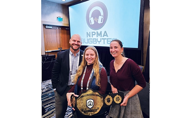 During the “BugBytes” live recording at PestWorld 2024 in Denver, Colo., Dr. Michael Bentley presented co-hosts Ellie Sanders and Laura Rosenwald with a specially designed BugBytes World Championship Podcasting Belt. The live podcasts have been held at PestWorld since 2021, and audience members are eligible for continuing education units. PHOTO: NPMA